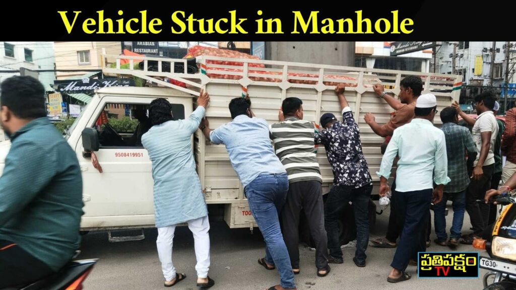 Hyderabad: Vehicle Stuck in Manhole at Panjagutta Citizens push a goods vehicle stuck in an open manhole near Panjagutta Metro pillar no.1116, Hyderabad – Prathipaksham TV photo